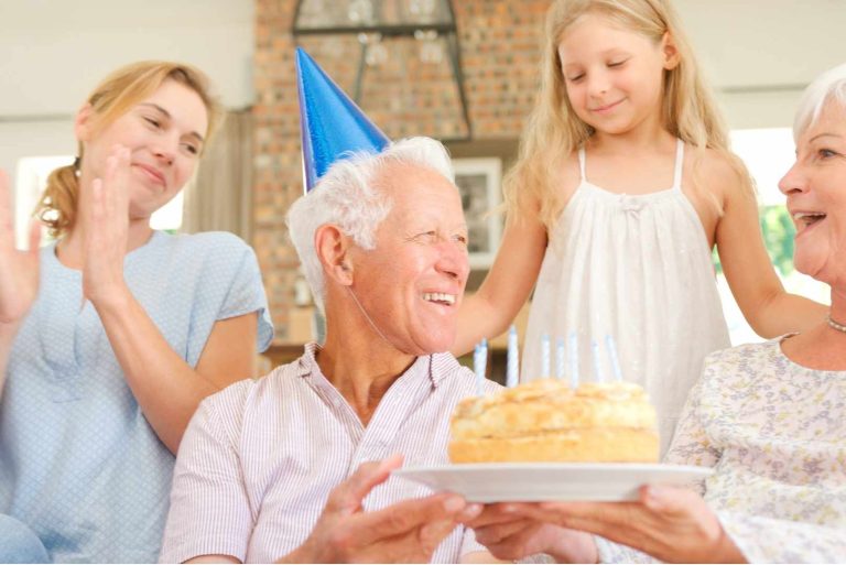 Family Sitting at Home Celebrating Grandfather's Birthday with Party and Cake.