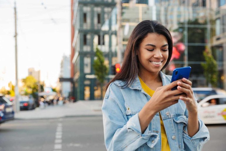Young African Woman Smiling Using Mobile Phone