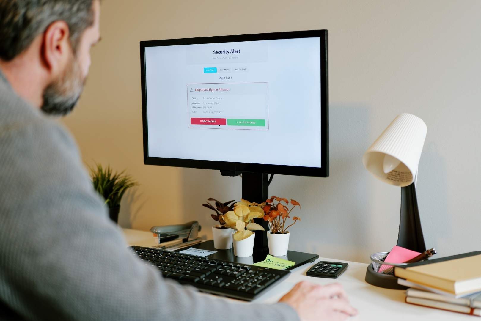 A computer screen displays a security alert for a suspicious sign-in attempt, with options to deny or allow access.
